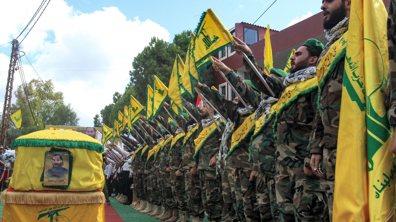 Members of the Lebanese Shiite Movement Hezbollah salute during the funeral of a comrade who was killed the previous day by the explosion of a communication device, in Adloun south of Tyre in southern Lebanon on September 19, 2024.