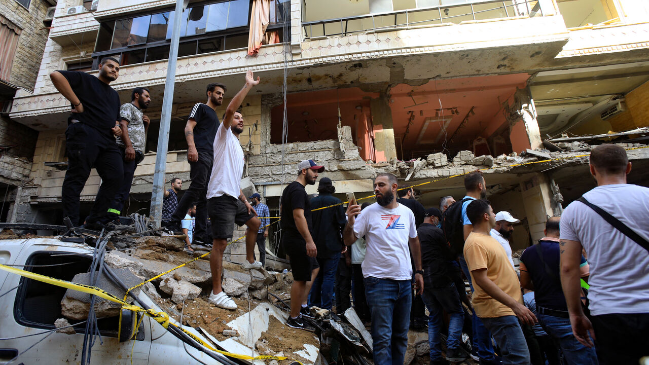 TOPSHOT - People gather in front of a building targeted by an Israeli strike in Beirut's southern suburbs on September 20, 2024. The strike on Hezbollah's stronghold in Lebanon's capital Beirut reportedly killed at least eight people and wounded dozens of others, with a source close to the movement saying a top military leader was dead. (Photo by AFP) (Photo by -/AFP via Getty Images)