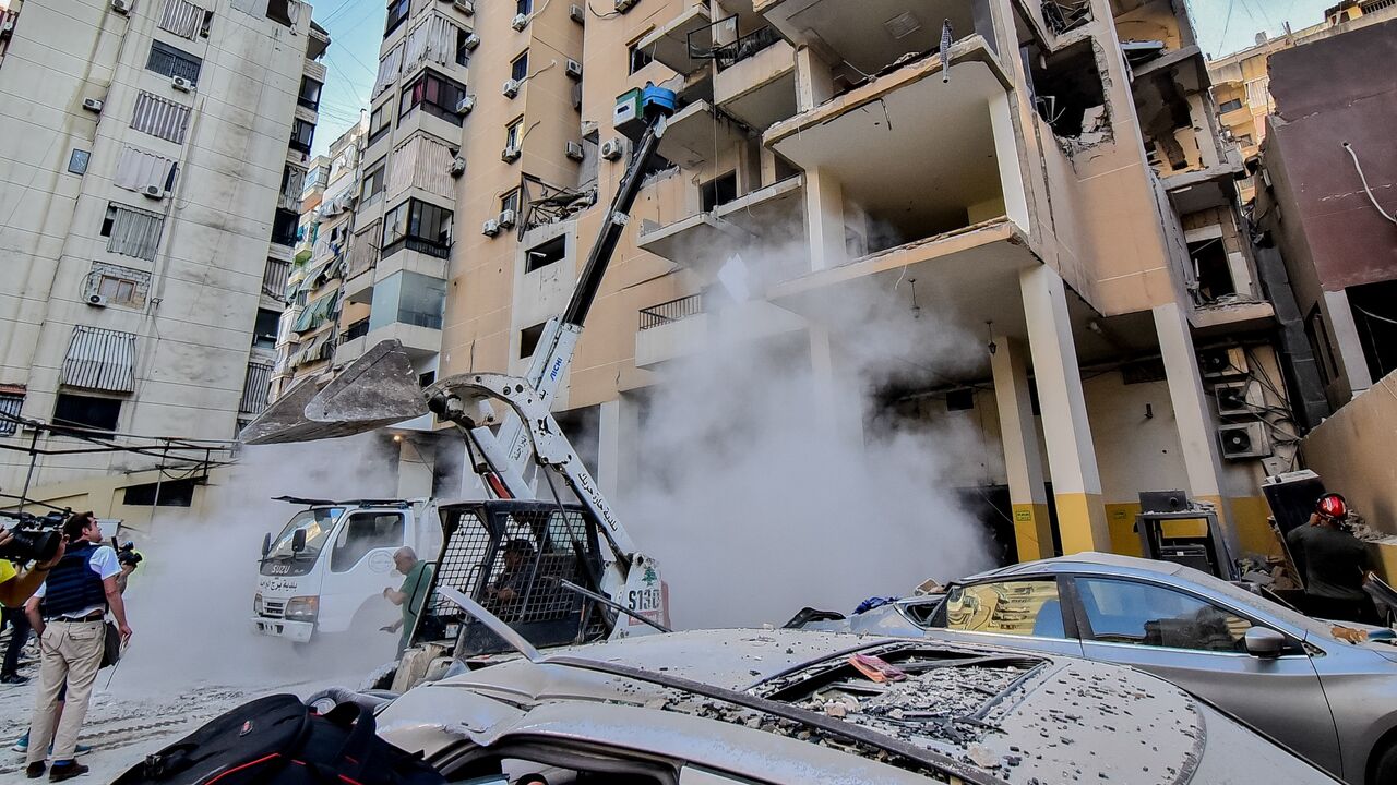 Local residents inspect damaged buildings and vehicles following an Israeli airstrike on Dahiyeh amid an escalation in cross-border warfare with the Lebanese group Hezbollah in Beirut, Sep. 26, 2024. 