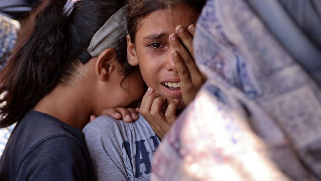 Children react following an Israeli strike on a school sheltering displaced Palestinians in Gaza