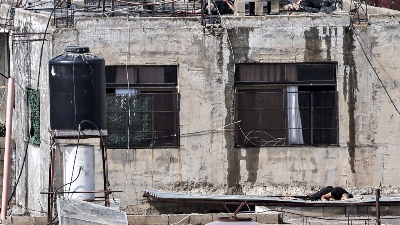 The bodies of three men killed during an Israeli army raid lie on the roof of a building, and just below it, in Qabatiya near Jenin in the occupied West Bank 