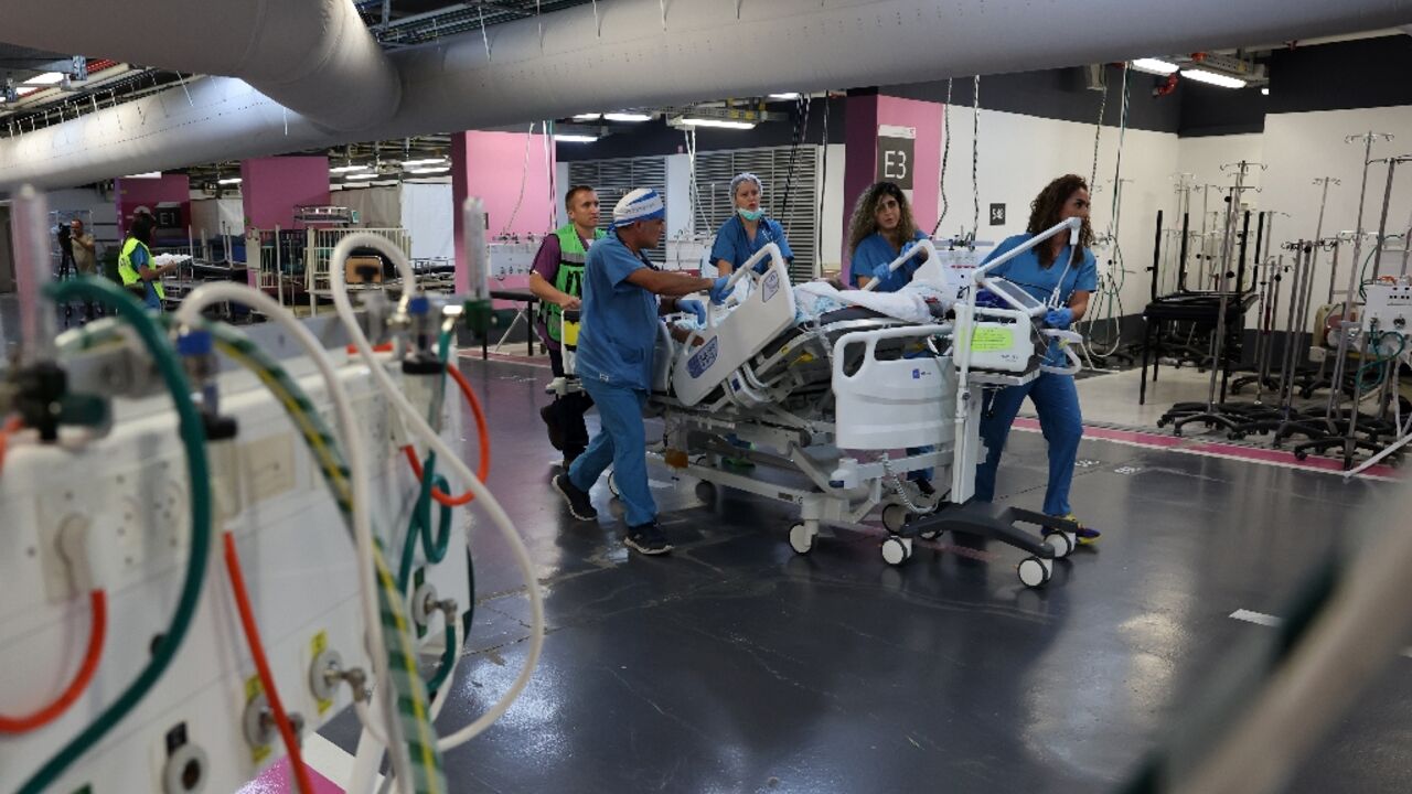 Medics wheel a patient into the underground parking area of Haifa's Rambam hospital