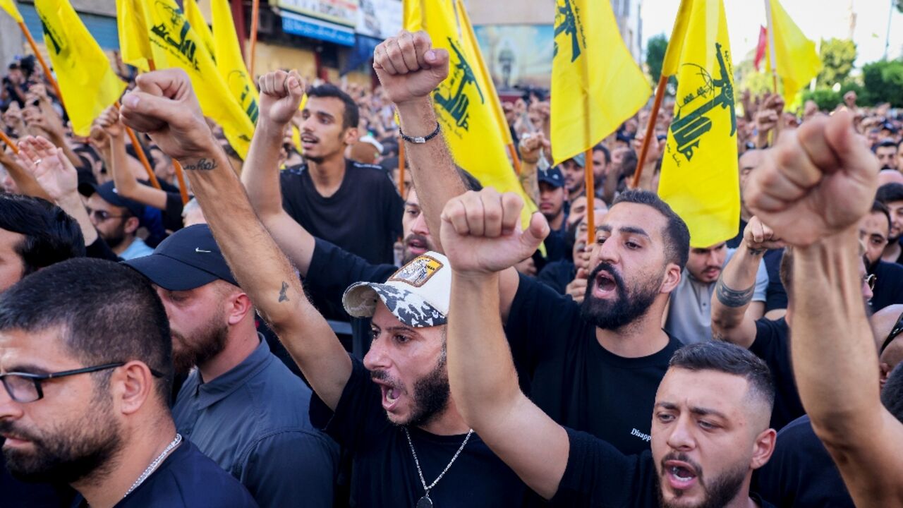 Mourners, some waving Hezbollah flags, attend the funeral of group members killed in an Israeli strike on Beirut