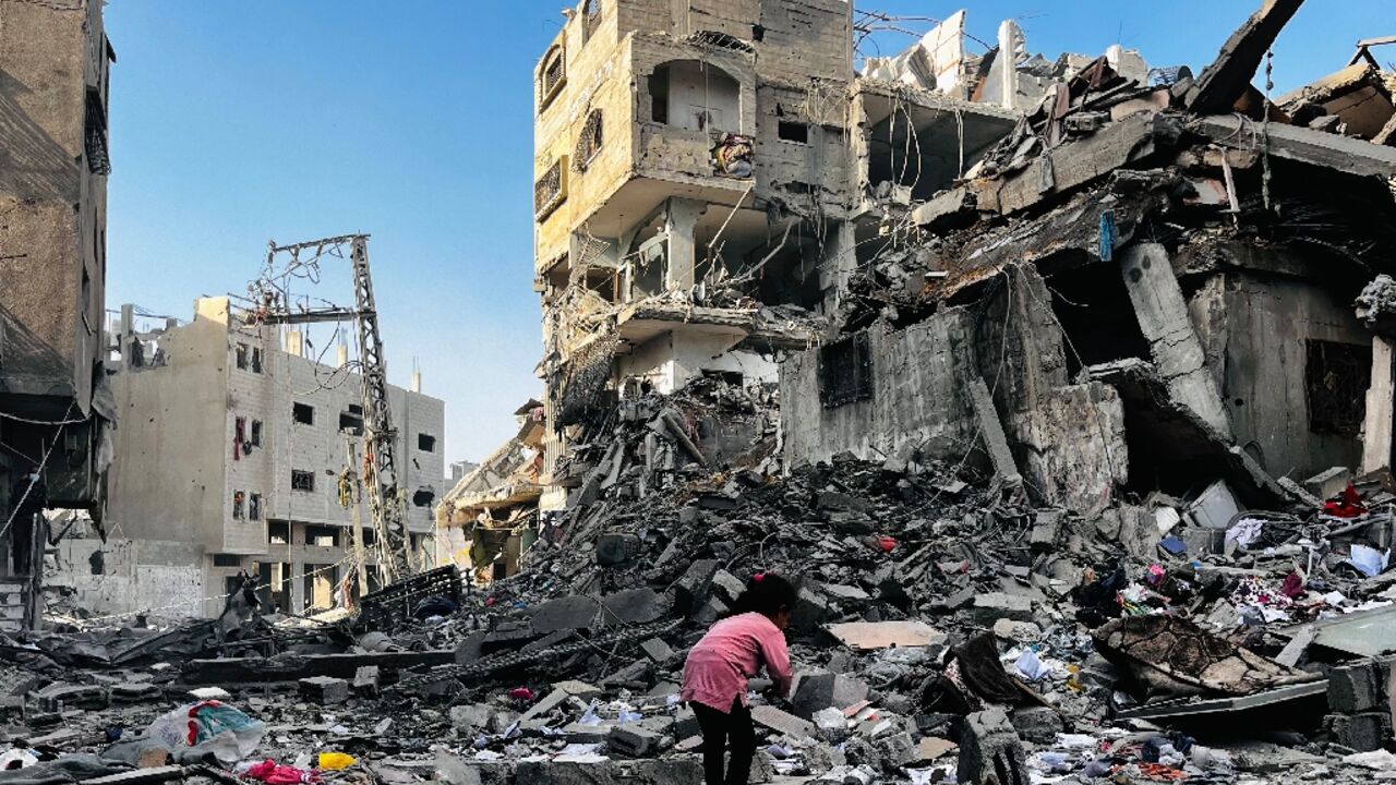 A Palestinian girl inspects the rubble of a building in the north Gaza district of Beit Lahia after an Israeli strike that the civil defence agency said killed 93 people