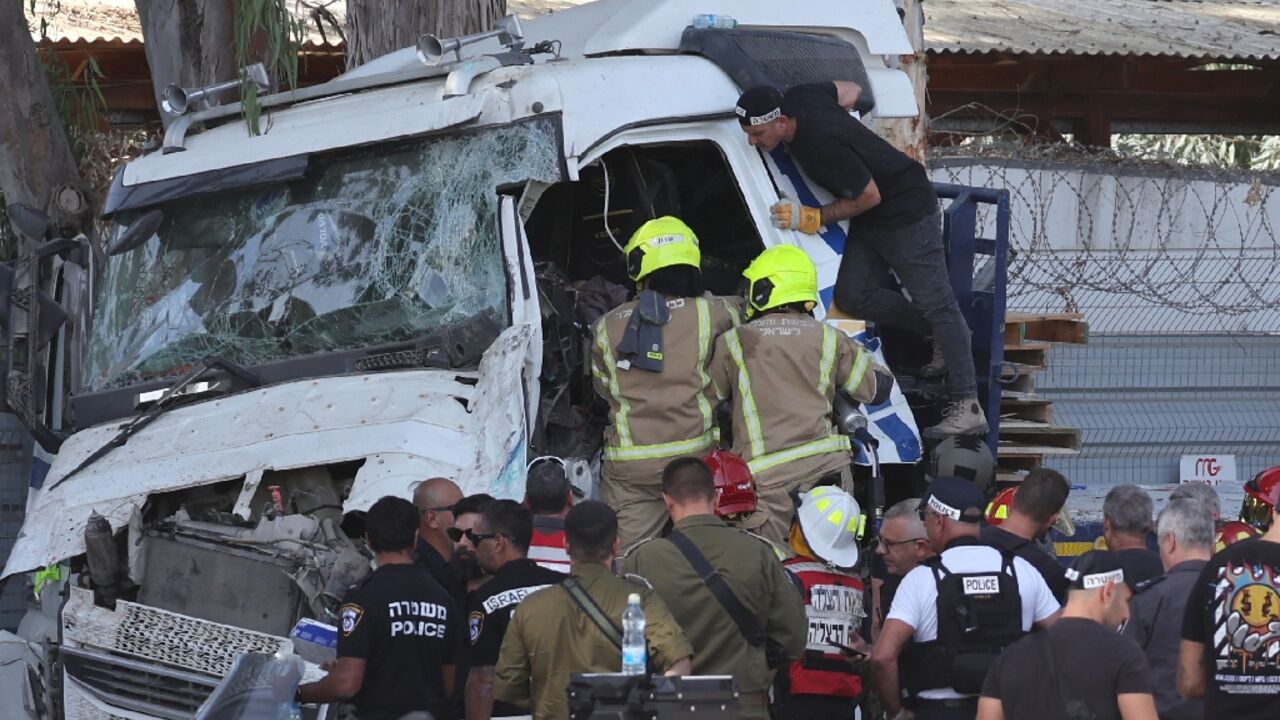 Israeli police and emergency responders recover the body of the truck driver at the site of a ramming in Ramat HaSharon, north of Tel Aviv