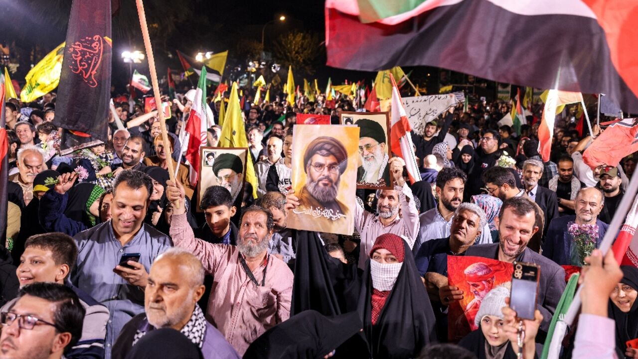A crowd celebrated the Iranian strikes on Tuesday in Tehran, some of them holding posters of slaim Hezbollah leader Hassan Nasrallah A crowd celebrated the Iranian strikes on Tuesday in Tehran, some of them holding posters of slaim Hezbollah leader Hassan Nasrallah