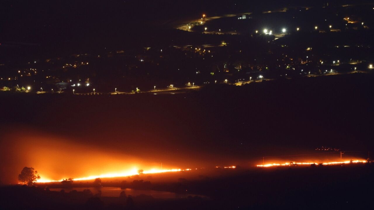 Fires burn as a result of rockets launched from Lebanon into northern Israel, next to the city of Kiryat Shmona near the Lebanon border