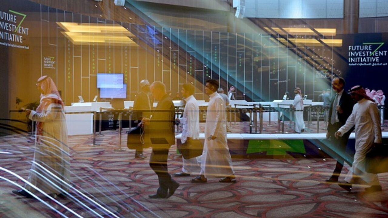 A photograph taken on October 28, 2019 shows Saudi and foreign journalists at the Future Investment Initiative (FII) badge collection centre in the Saudi capital Riyadh. - Top finance executives and political leaders have converged on Saudi capital Riyadh for a Davos-style investment forum, in stark contrast to last year's mass boycott following the murder of dissident journalist Jamal Khashoggi. US officials and the heads of giant banks, top asset management firms and major sovereign wealth funds top the g
