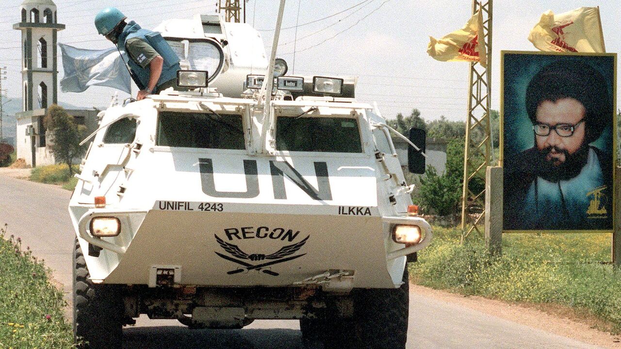 A UNIFIL personnel carrier drives by a picture of late Hezbollah leader Sheikh Abbas al-Mussawi May 2, 2000, in the village of Ghandourieyh in south Lebanon.