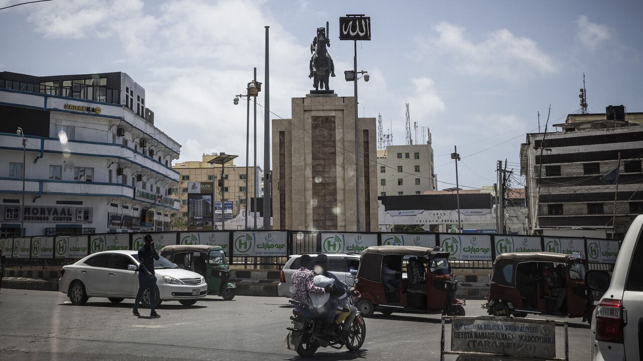 Auto rickshaws (Tuk-Tuks) and a monument are seen through the window of an armoured car on Sept. 4, 2022 in Mogadishu, Somalia. 