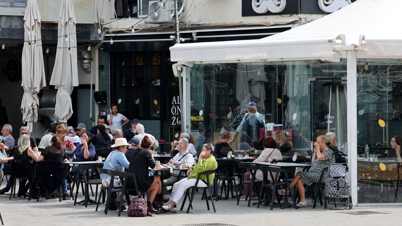 Israelis sit in a coffee shop in the Israeli coastal city of Netanya, on April 14, 2024, one day after Iran launched its first-ever direct attack on Israeli territory.