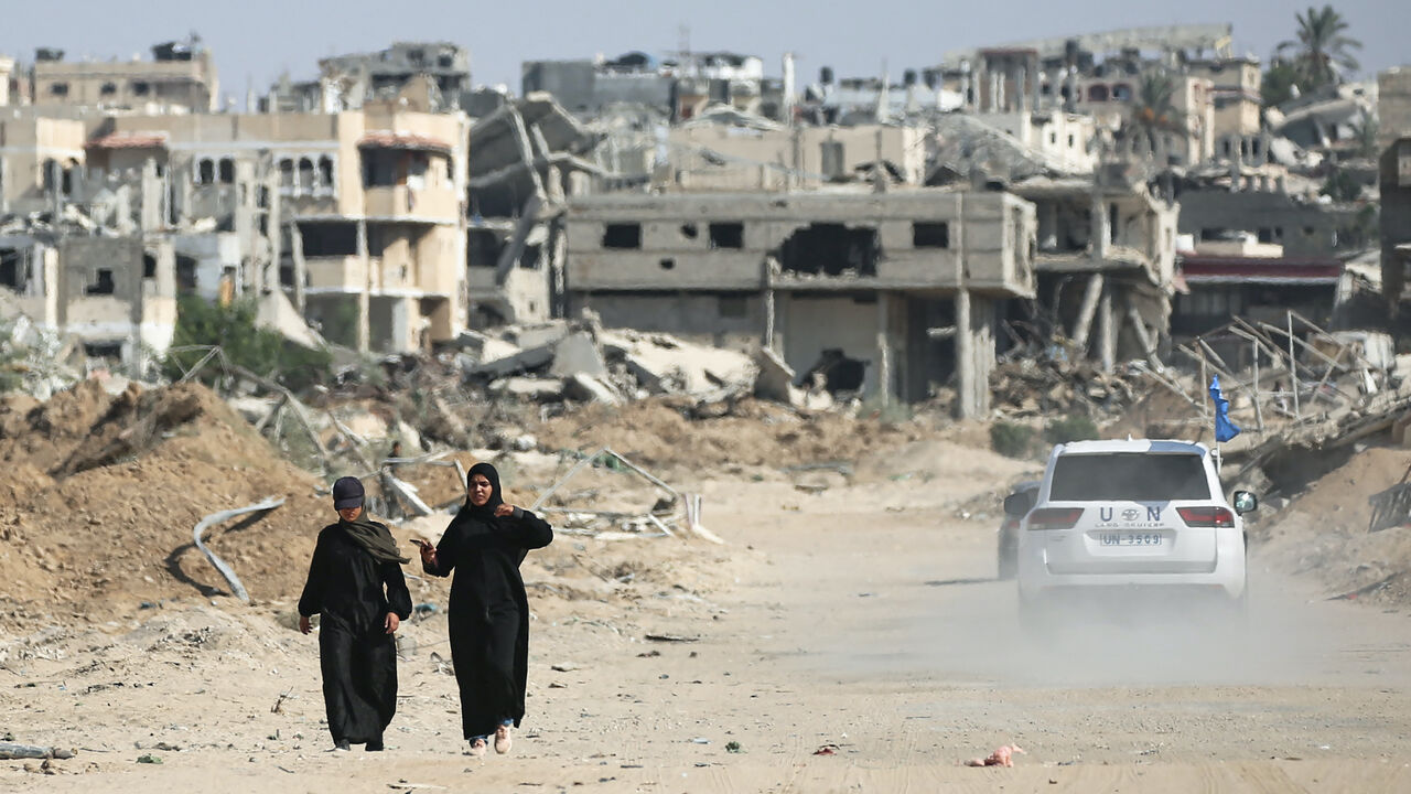 Palestinians walk past destruction and a UN vehicle in Khan Yunis in the southern Gaza Strip on Sept. 10, 2024, amid the ongoing war between Israel and Palestinian militant group Hamas.