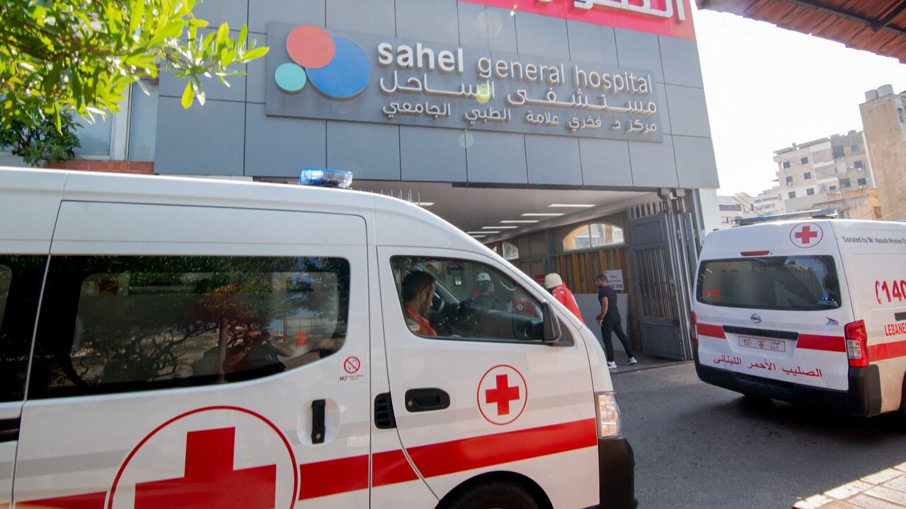 Ambulances and paramedics carry people wounded in an Israeli bombing of Beirut to Sahel Hospital.