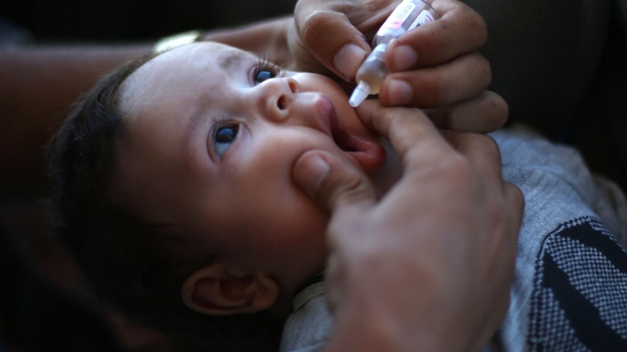 A medic administers a polio vaccine to a Palestinian child in Khan Yunis in the southern Gaza Strip A medic administers a polio vaccine to a Palestinian child in Khan Yunis in the southern Gaza Strip