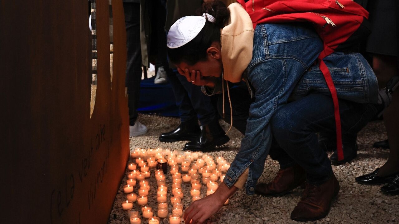 A mourner in Nice, France, lays down a candle at a ceremony in tribute of the victims of October 7 attack A mourner in Nice, France, lays down a candle at a ceremony in tribute of the victims of October 7 attack