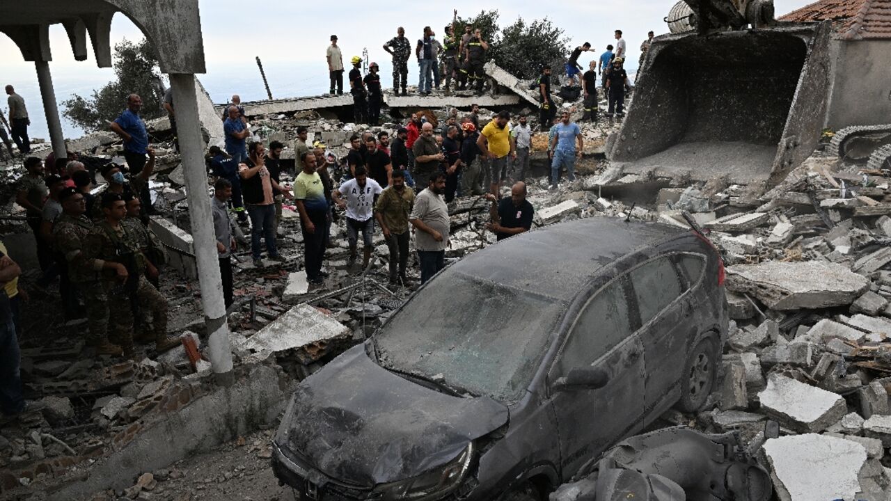 People inspect the damage at the site of an Israeli air strike on Maaysra People inspect the damage at the site of an Israeli air strike on Maaysra