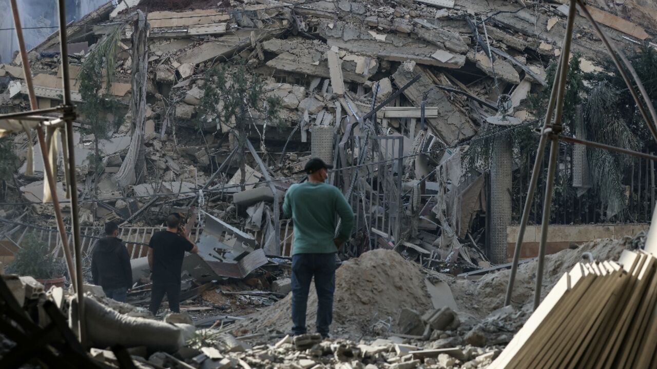 Residents stand in front of a levelled building following an Israeli airstrike that targeted the neighbourhood of Chiyah in Beirut's southern suburbs Residents stand in front of a levelled building following an Israeli airstrike that targeted the neighbourhood of Chiyah in Beirut's southern suburbs
