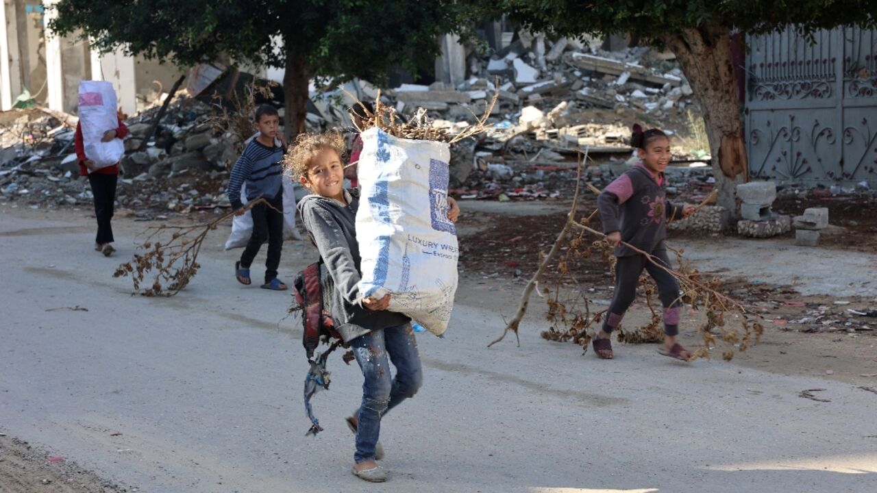 Palestinian children carry firewood to their homes in Jabalia on November 20