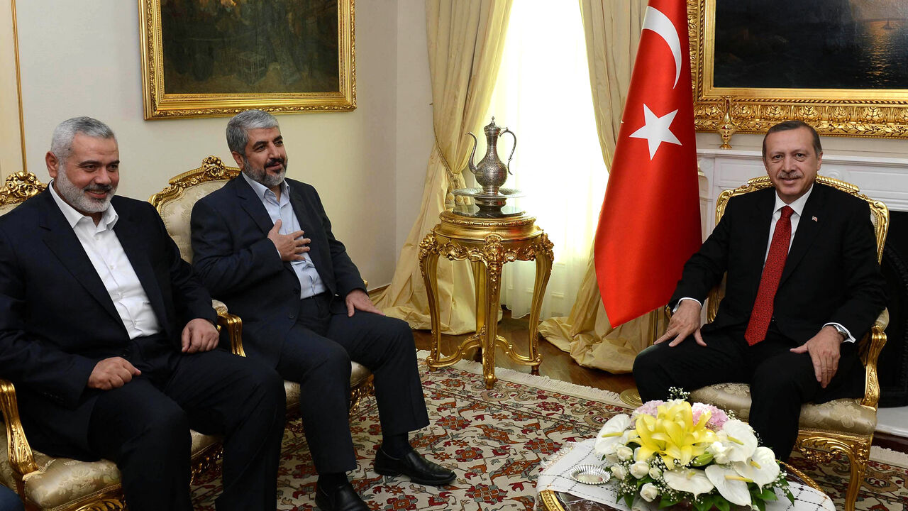 Turkish Prime Minister Recep Tayyip Erdogan (R) poses beside Khalid Mashaal (C), the Hamas chief in exile, and Gaza's prime minister Ismail Haniyeh prior to their meeting in Ankara on June 18, 2013. Senior leaders of the Palestinian Islamist movement Hamas met today in Ankara with Turkish Prime Minister Erdogan to discuss Erdogan's planned visit to the Gaza Strip as well as the situation in Syria, the source said on condition of anonymity. AFP PHOTO/ PRIME MINISTER PRESS OFFICE/ YASIN BULBUL == RESTRICTED T