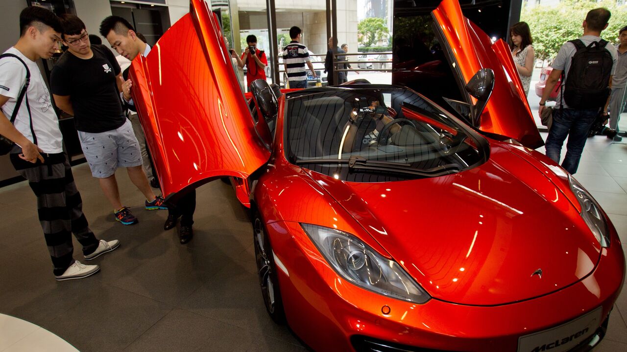 A group of people are seen visiting the first Chinese dealership unveiled by British supercar maker Mclaren Automotive on Sept. 12, 2013 in Shanghai.