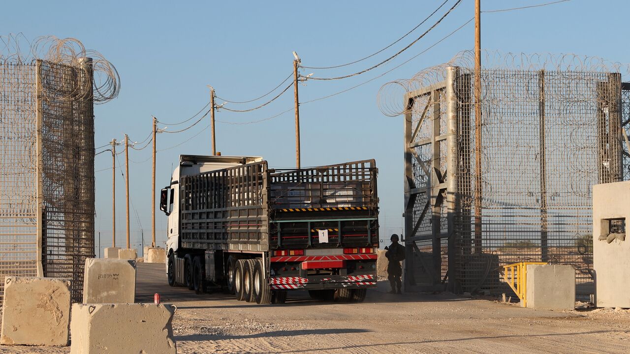 Trucks loaded with humanitarian aid delivered from Jordan cross into Gaza.