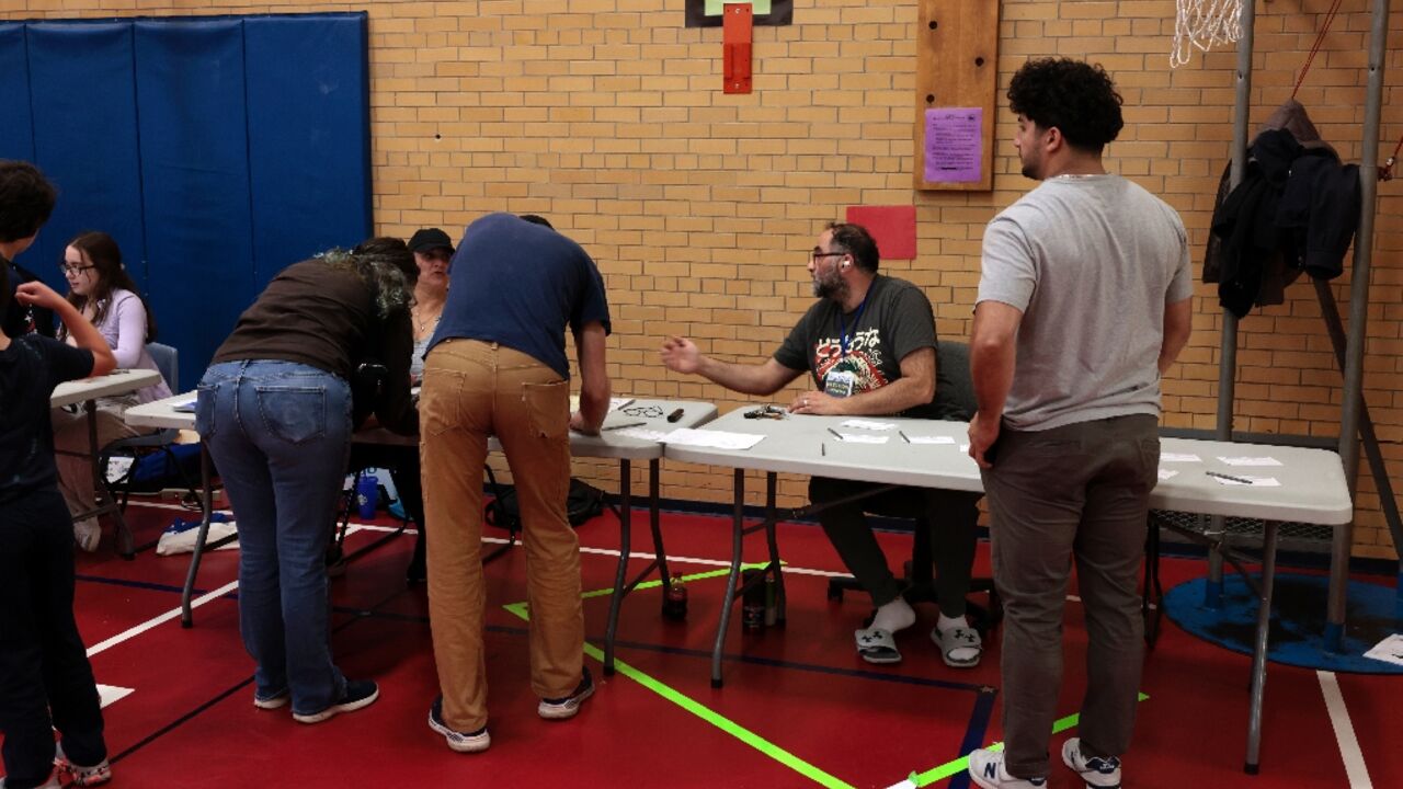 Voters check in and request their ballots at a polling station at Charles A. Lindbergh Elementary School in Dearborn, Michigan