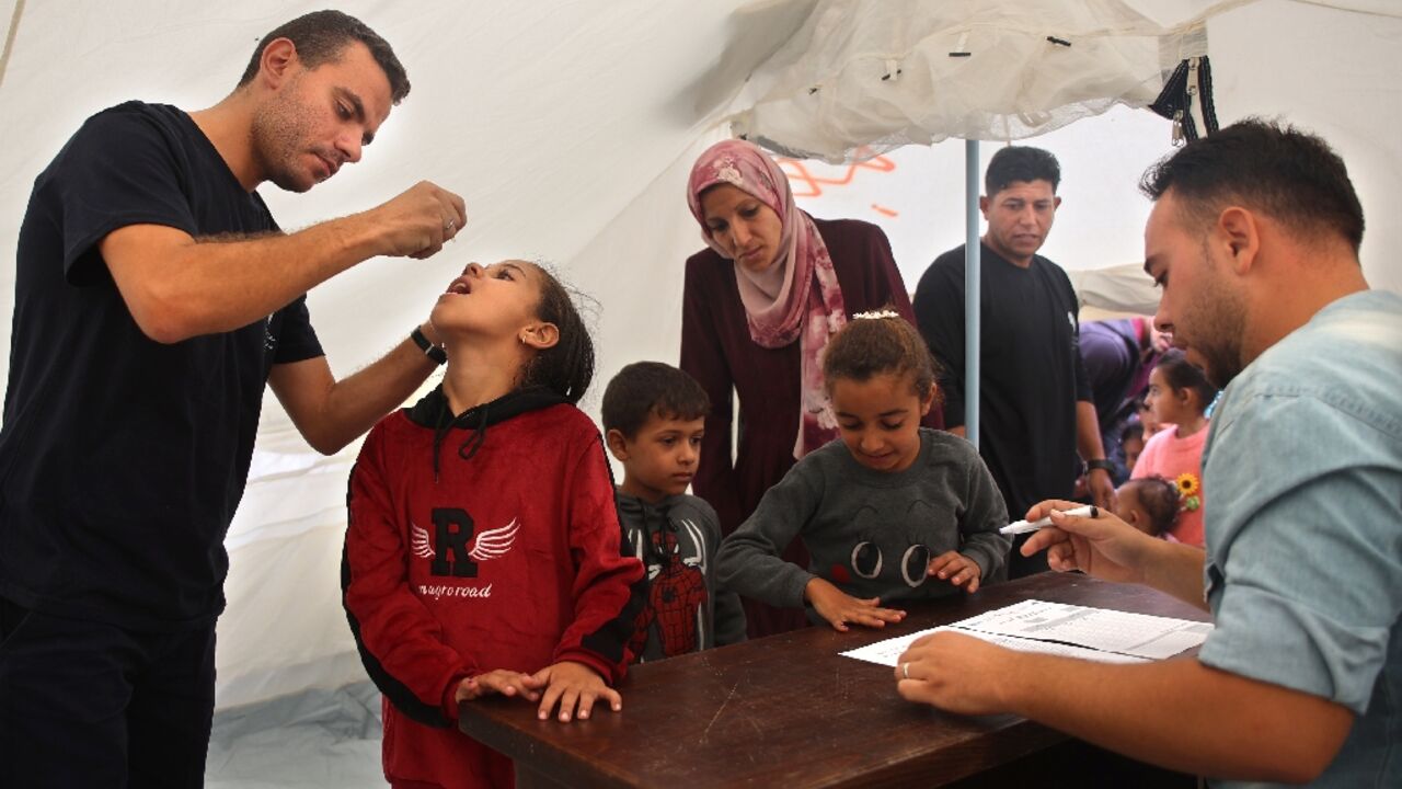 A medic administers polio vaccine to a Palestinian child at Abdel Aziz Rantissi hospital in the Gaza City area of north Gaza -- the campaign resumed after a halt due to Israeli bombing A medic administers polio vaccine to a Palestinian child at Abdel Aziz Rantissi hospital in the Gaza City area of north Gaza -- the campaign resumed after a halt due to Israeli bombing