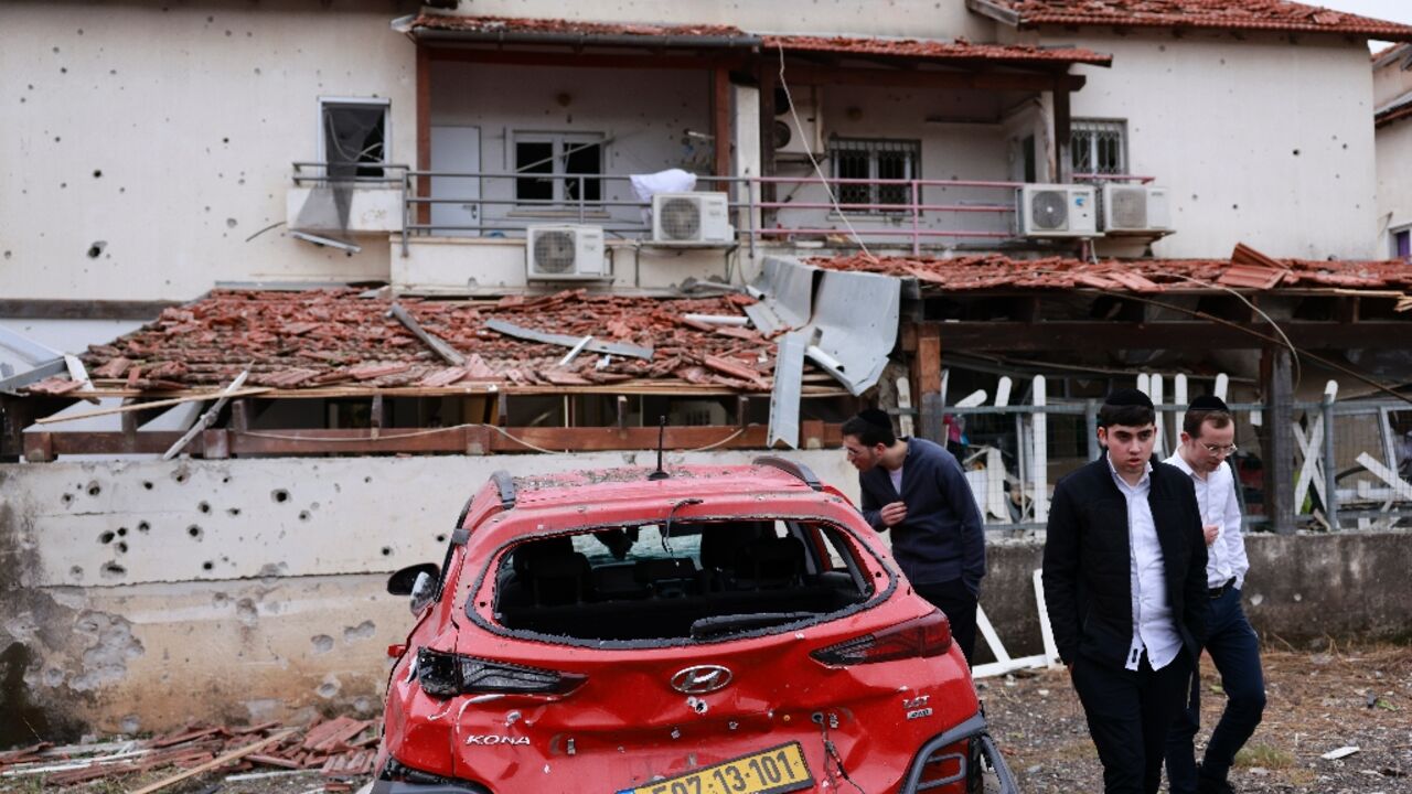 Residents in Petah Tikva near Tel Aviv inspect the damage after rockets were fired from Lebanon 