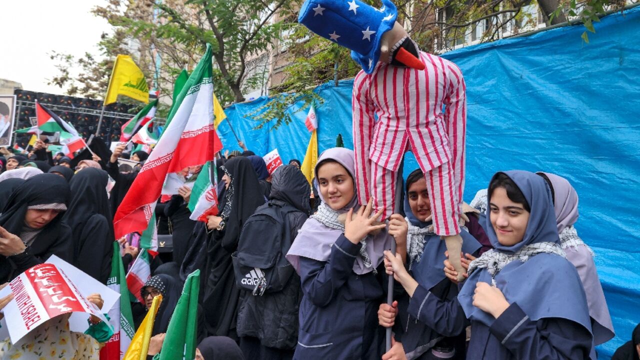 Women hold an Uncle Sam effigy during a rally outside the former US embassy in Tehran