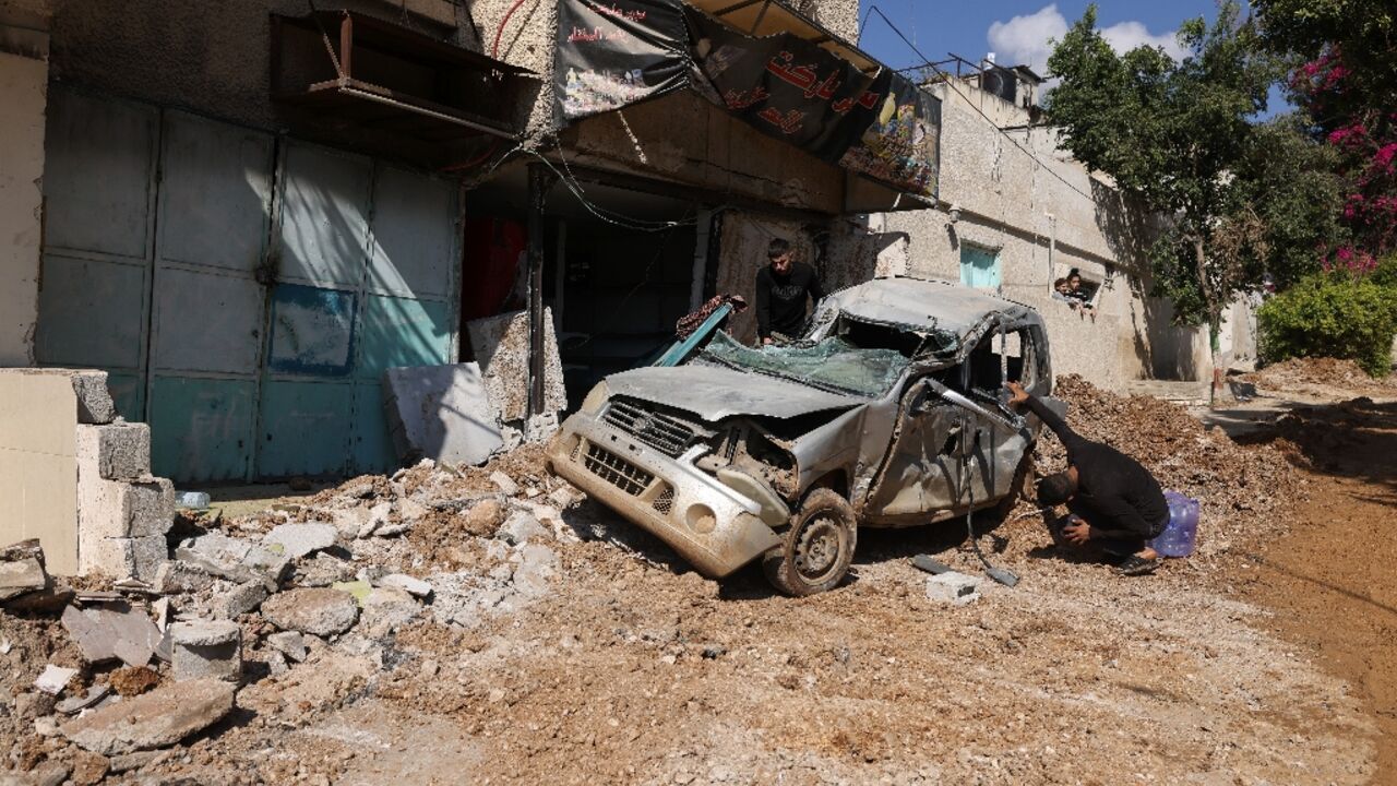 People inspect a destroyed car following an Israeli raid at the Al-Fara refugee camp north of Nablus in the occupied West Bank People inspect a destroyed car following an Israeli raid at the Al-Fara refugee camp north of Nablus in the occupied West Bank