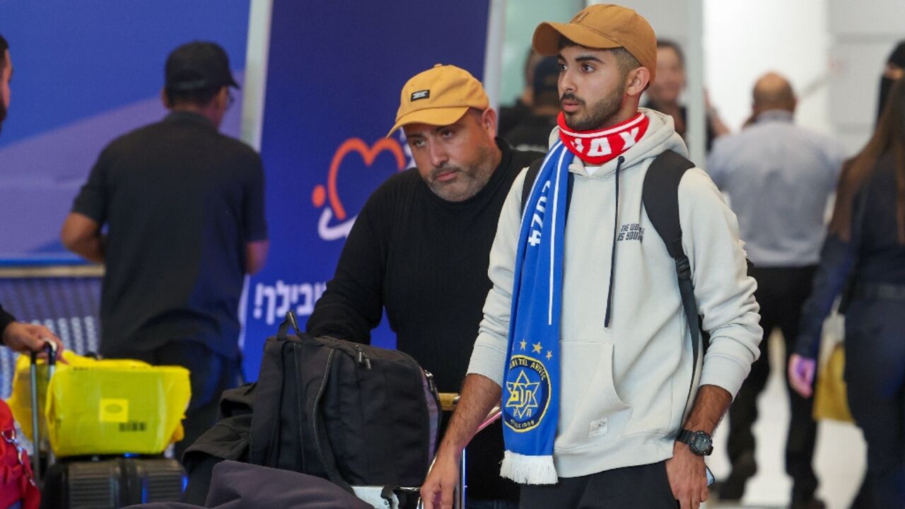 A fan wearing Maccabi Tel Aviv and Ajax scarves arriving at the Ben Gurion International Airport near Israel's Tel Aviv