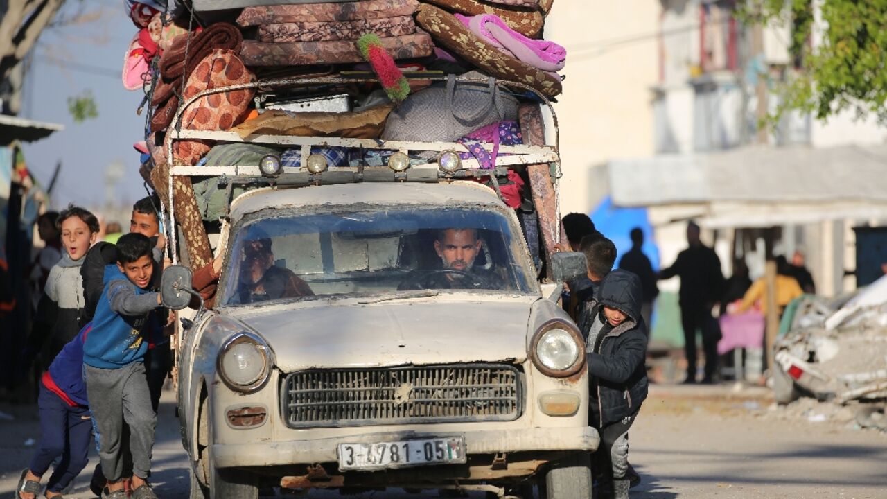 Palestinian children help push a heavily laden vehicle in Gaza's Bureij refugee camp as residents flee in response to the latest evacuation warning from the Israeli military. Palestinian children help push a heavily laden vehicle in Gaza's Bureij refugee camp as residents flee in response to the latest evacuation warning from the Israeli military.