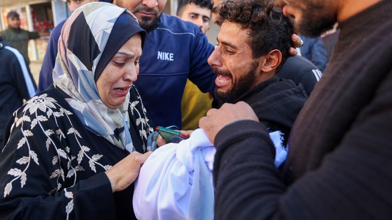 A woman cries over a two-year-old child killed in an Israeli strike in Gaza Thursday