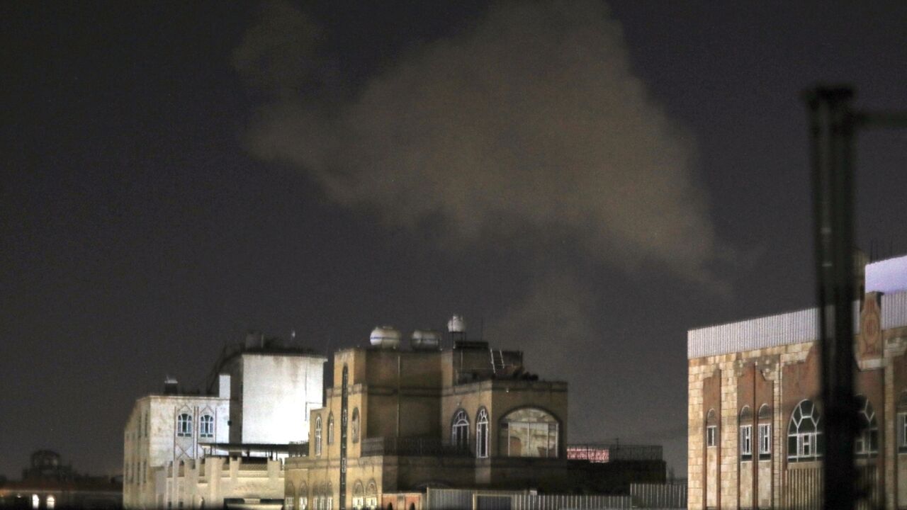 Smoke billows skywards after an air strike on Yemen's capital Sanaa late on December 27