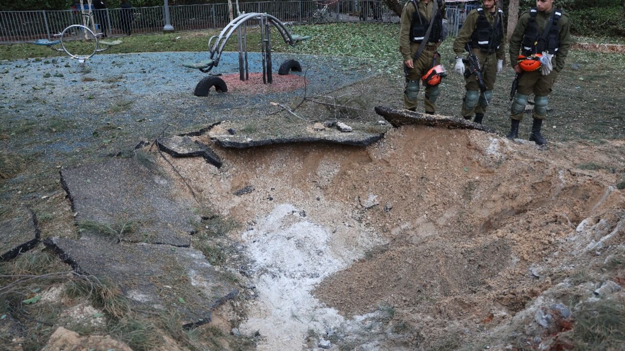 Israeli emergency responders inspect a crater at the site where a projectile fired from Yemen landed in Tel Aviv on December 21, 2024 Israeli emergency responders inspect a crater at the site where a projectile fired from Yemen landed in Tel Aviv on December 21, 2024