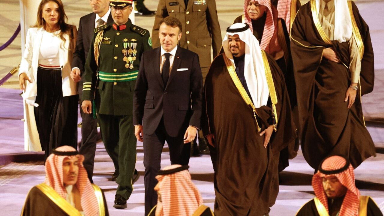 French President Emmanuel Macron (C) was received by the deputy governor of the Riyadh region, Prince Mohammed bin Abdulrahman bin Abdulaziz (C-R)