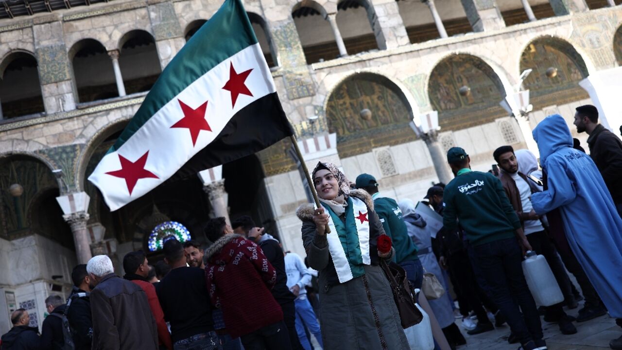 Many people held Syria's independence-era flag as they celebrated Friday prayers at the Umayyad Mosque Many people held Syria's independence-era flag as they celebrated Friday prayers at the Umayyad Mosque