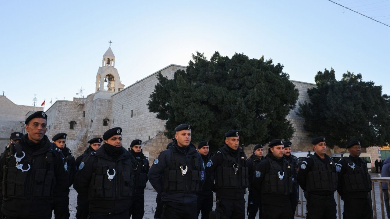 Palestinian policemen stand guard at Manger Square on Christmas eve outside Bethlehem's Church of the Nativity