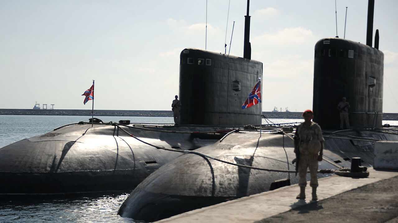 A Russian soldier stands next to submarines at the Russian naval base in the Syrian Mediterranean port of Tartus on Sept. 26, 2019. 