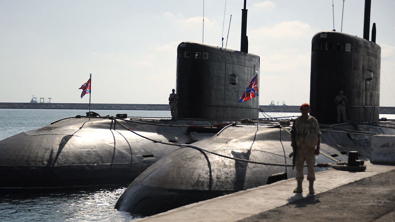 A Russian soldier stands next to submarines at the Russian naval base in the Syrian Mediterranean port of Tartous, on Sept. 26, 2019.