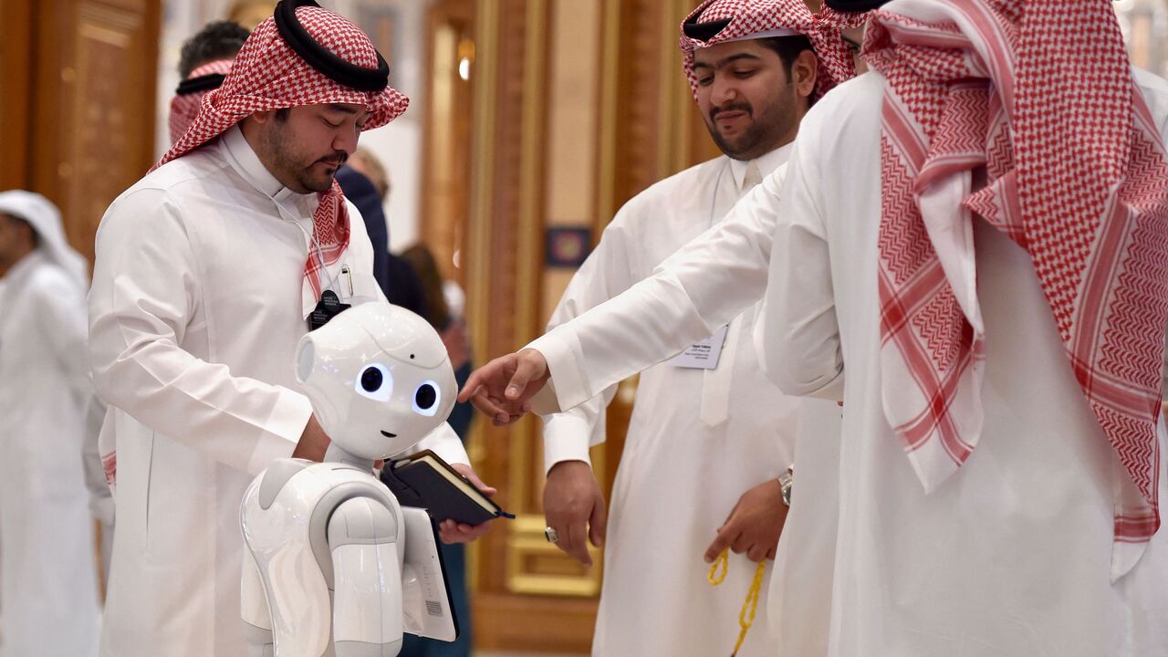 Delegates chat near a robot during the Future Investment Initiative (FII) forum at the King Abdulaziz Conference Centre in Saudi Arabia's capital Riyadh, on Oct. 30, 2019. 