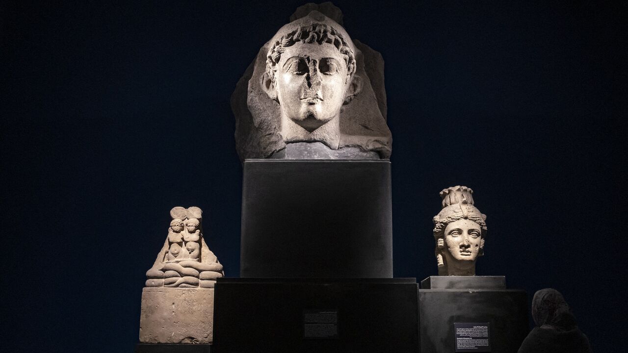 A visitor views the busts of Cleopatra VII Thea Philopator.