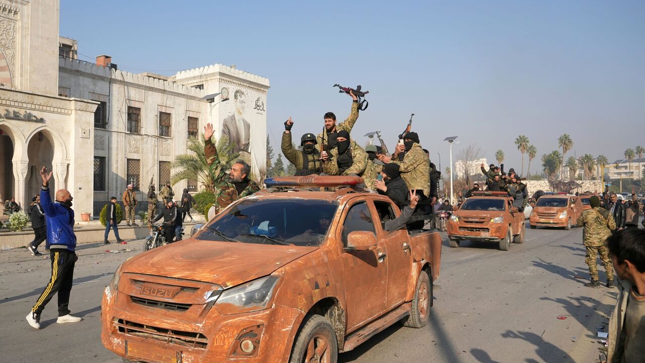 Syrian anti government fighters celebrate as they pour into the captured central-west city of Hama on Dec. 6, 2024.