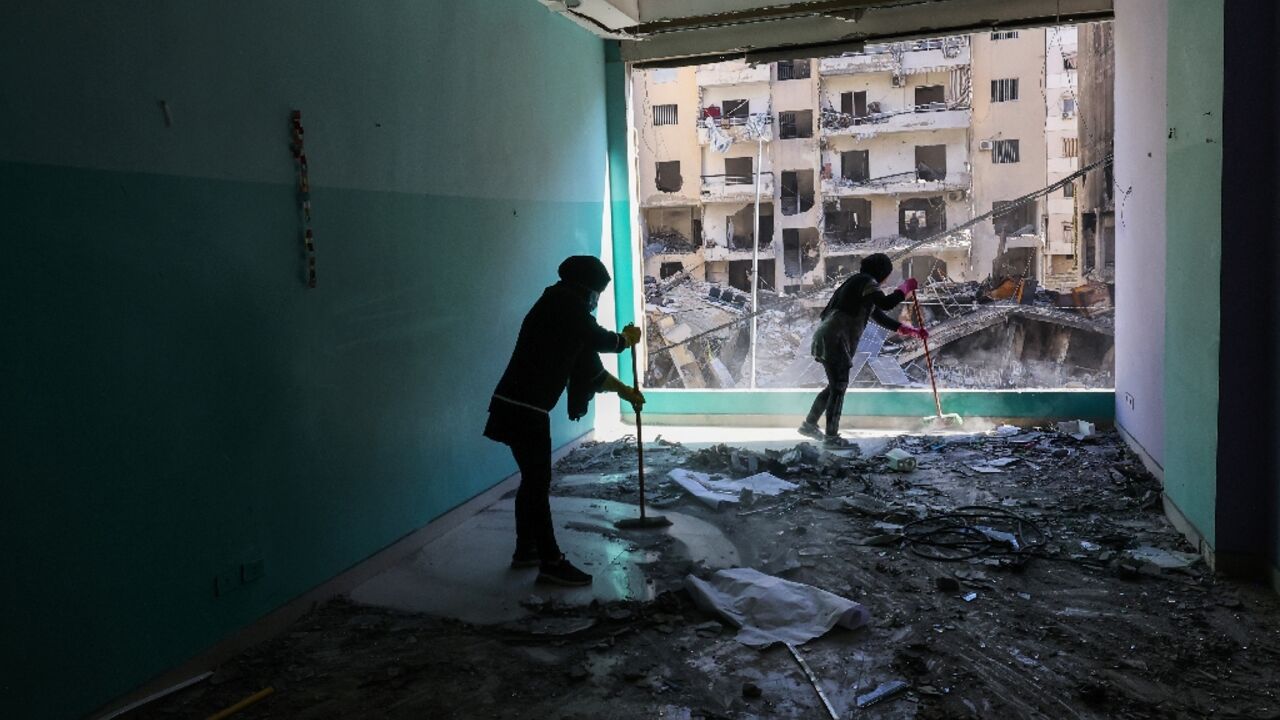 Staff members of the Amel Association, a Lebanese non-governmental organisation, clear debris at their branch that was damaged in an Israeli strike on a nearby building