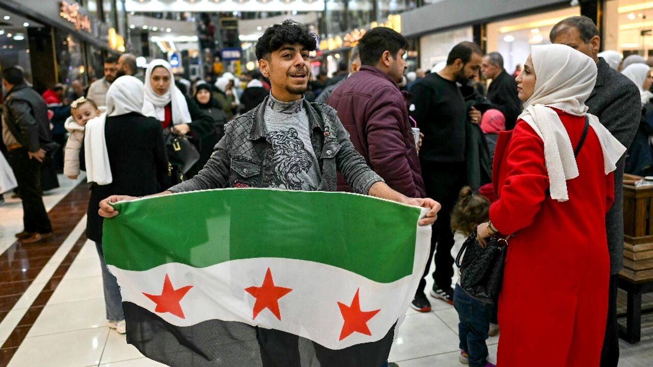 A young man holds a Syrian independence flag in a shopping mall near Sarmada, in the northern province of Idlib A young man holds a Syrian independence flag in a shopping mall near Sarmada, in the northern province of Idlib