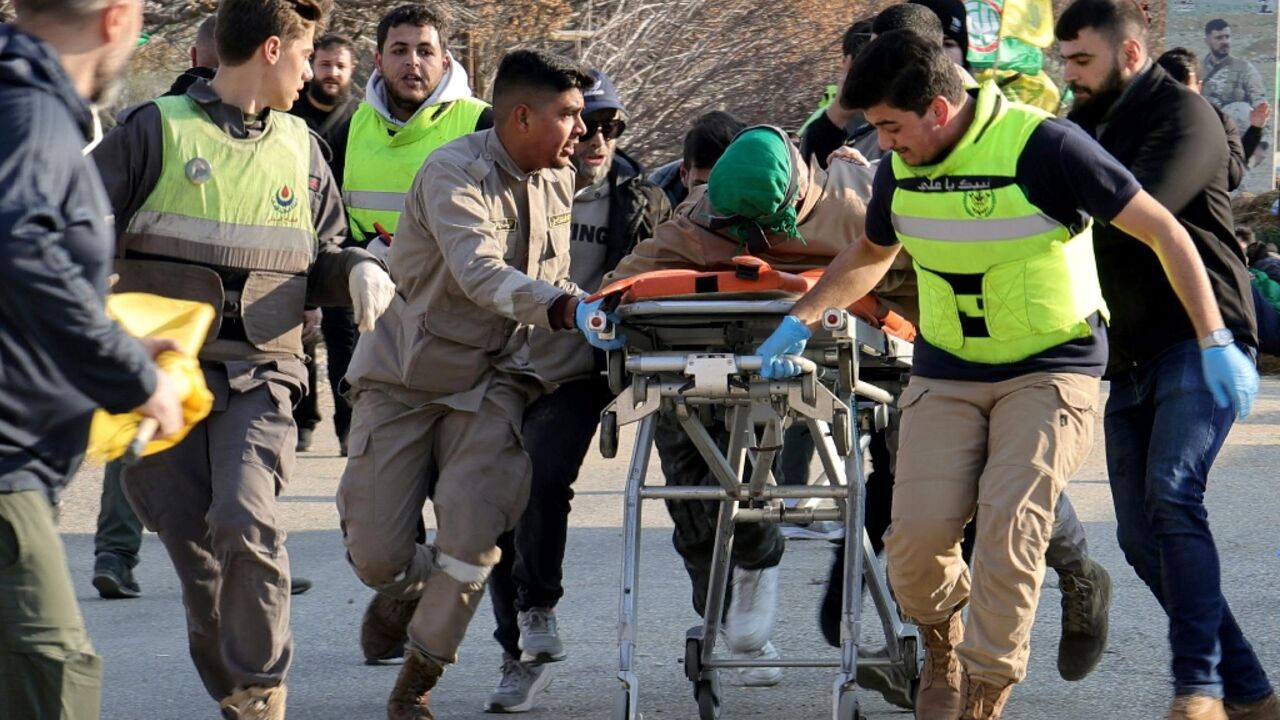 Medics move a wounded man towards an ambulance at a Lebanese army checkpoint in Burj al-Muluk, southern Lebanon, after Israeli soldiers reportedly shot him while residents tried to reach the village of Kfar Kila