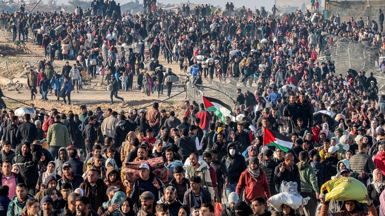 People walk northwards along a coastal in Gaza after Israel opened the way following a deal on future hostage exchanges