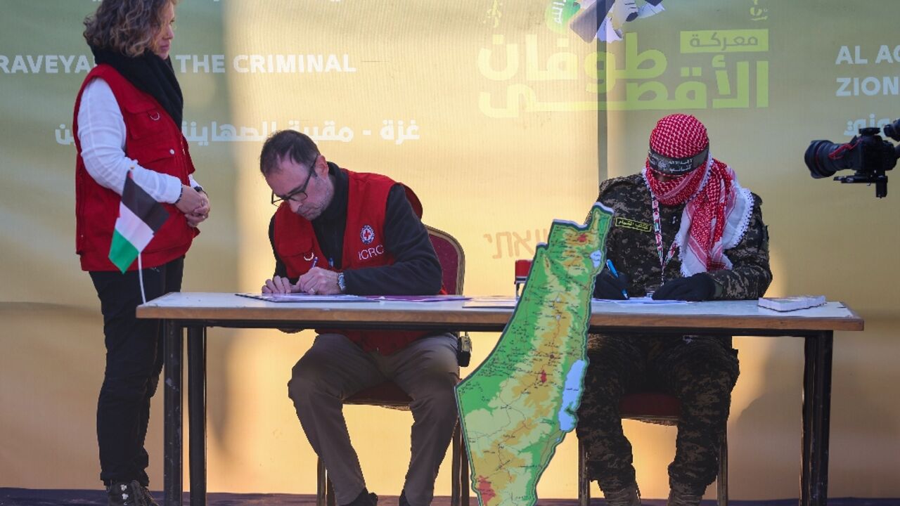 A Red Cross member signs documents before Hamas militants release Israeli hostage Agam Berger in Jabalia