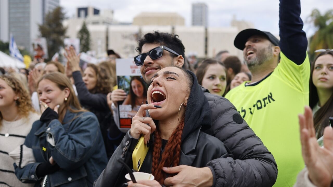 Members of a crowd gathered in Tel Aviv react during the livestreamed release of four women soldiers held hostage in Gaza 