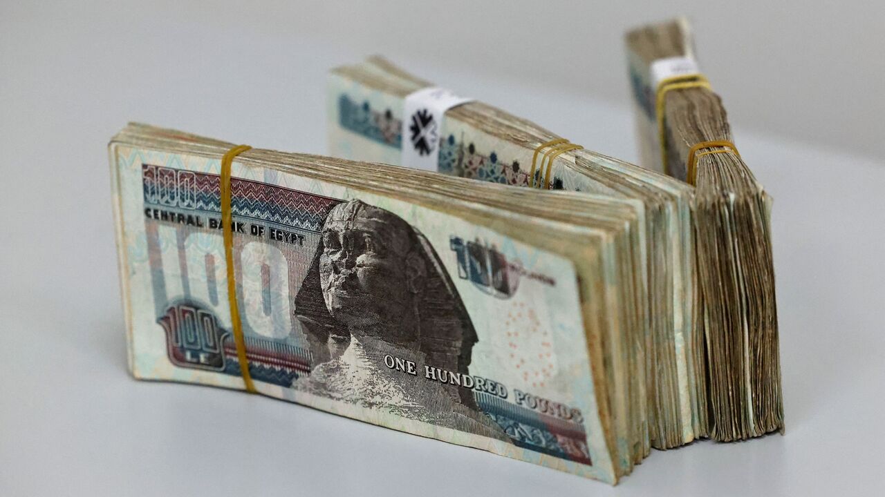 Egyptian pound banknotes sit on a table on March 6, 2024, in Cairo, after Egypt's central bank announced it will allow the exchange rate to be set by the market. 